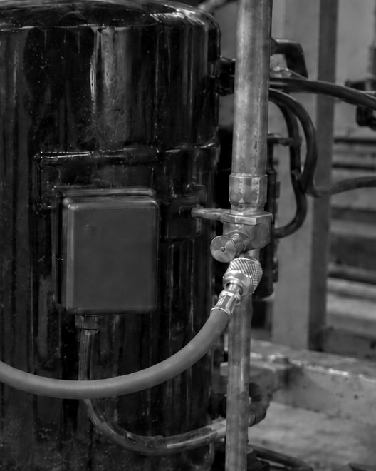 AI-generated illustration of a sealed compressor with its terminal box, a service port and a hose connected to it